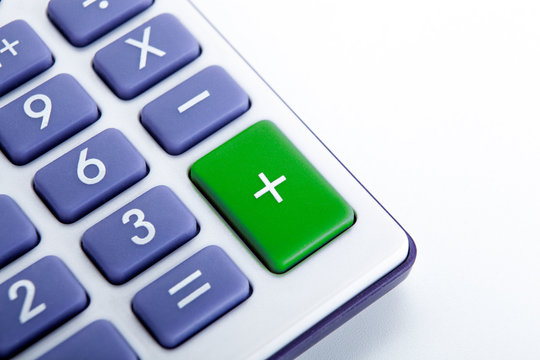 calculator with blue buttons with a green plus sign