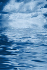 Water background with cloudy sky blue toned