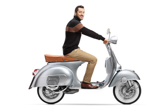 Young elegant man riding a vintage scooter and looking at the camera