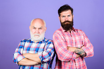 Father and son. Men bearded hipster stand back to back. Family team. Brutal guys with long beard. Barbershop concept. Barber well groomed handsome bearded man. Bearded friends. Hairdresser salon