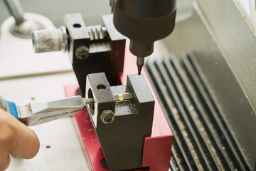 Key duplication machine operated by a locksmith in the process of duplicating a key