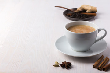 Traditional indian masala tea in a white cup on a white background with copy space