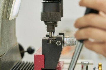 Key duplication machine operated by a locksmith in the process of duplicating a key