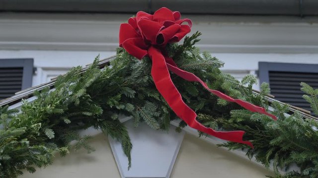 Close Up Christmas Garland On White House Red Ribbon