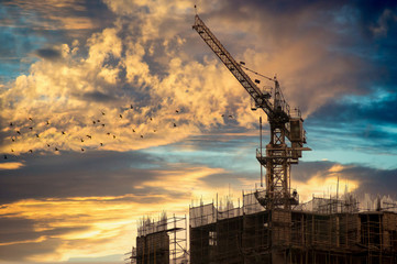 crane on top of an under construction building at dusk