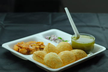 Indian Popular Famous Snacks Pani Puri Poori Phuchka Golgappe Cross Angled In Black Background and Blank Space
