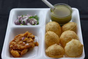 Indian Popular Famous Snacks Pani Puri Poori Phuchka Golgappe With Mashed Potato and Onion In Black Background and Blank Space