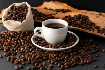 Cup of Coffee and Coffee Beans on Black Background, close-up
