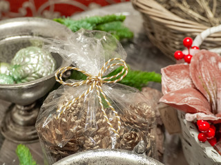Christmas composition of golden bow on a transparent bag with gold cones.  Pink poinsettia flower, balls, red berries  in white basket. Christmas and new year background 