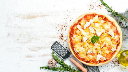 Traditional pizza with chicken, pineapple and corn. Top view. free space for your text. Rustic style.