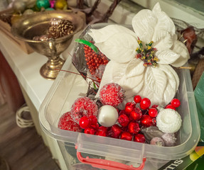 Christmas composition of red berries, white poinsettia flower, balls in plastic box. Christmas and New year background.