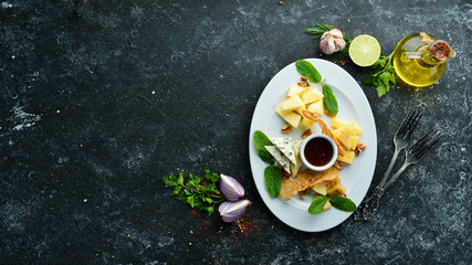 Assorted cheeses. Cheese slicing on a plate. Top view. free space for your text. Rustic style.