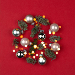 Christmas ball made of Christmas balls and spruce branches on red background.Creative New Year greeting card concept.