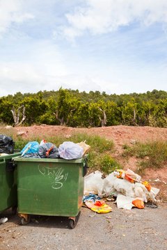 Overflowing bins next to Orange Orchard, Valencia region, Spain