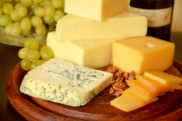 various types of cheese on a wooden board  