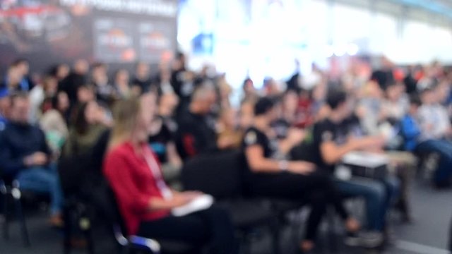 Blurred Background. Many people are sitting in the hall audience