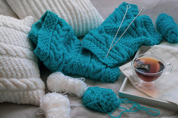 Christmassy fluffy white and knitted blue pillows in bedroom