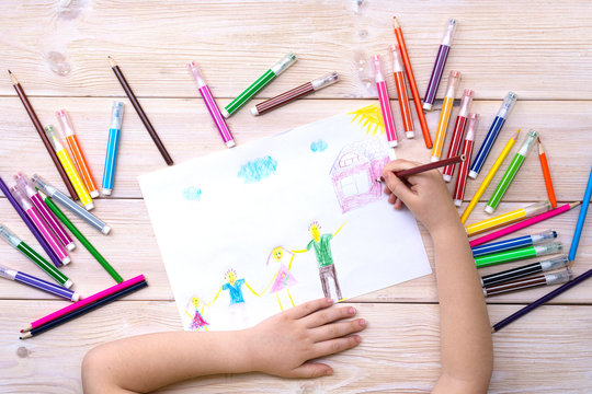 A child draws a birthday card with his family. Drawing made by a child with colorful felt-tip pens and pencils. Happy family. Child's drawing
