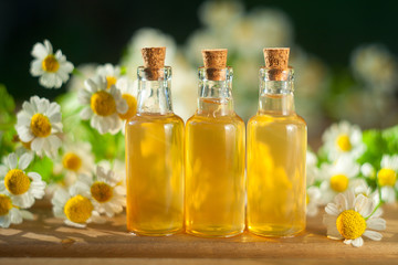 Essence of flowers on table in beautiful glass bottle