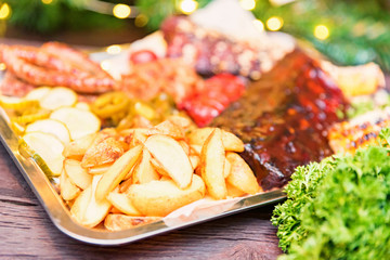 Dish of mixed meats. Grilled ribs, chicken and sausages served with baked potato