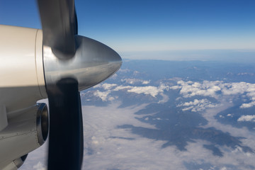 propeller of an airplane above white clouds