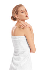 Beautiful young woman applying body scrub against white background