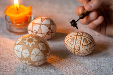 Woman paints an Easter egg, Ukrainian pysanka by hot wax