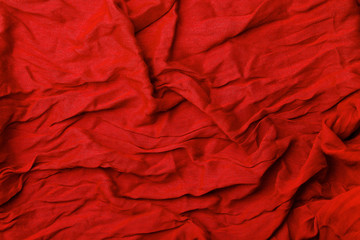 Red fabric background. Texture and folds of red fabric, copy space