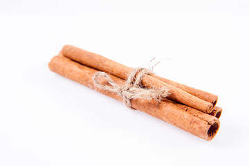 Cinnamon sticks tied with a jute twine on white background