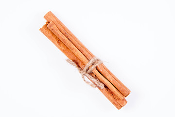 Cinnamon sticks tied with a jute twine on white background