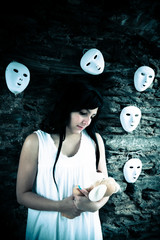 mentally confused woman with cuddly bear in front of a wall