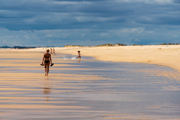 Woman walking on the beach in Cabanas de Tavira, Portugal