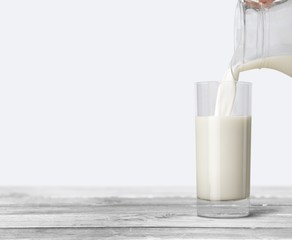 A glass of milk and bottle on wooden desk