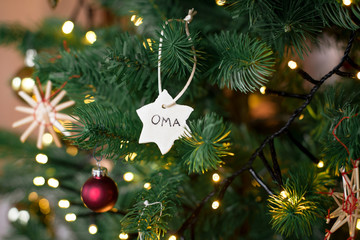 christbaumanhaenger selbstgemacht aus salzteig mit der aufschrift oma im weihnachtsbaum haengend...