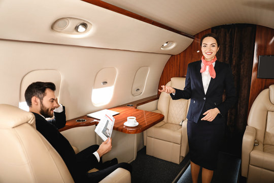 Air Hostess And Businessman On Board The Modern Private Airplane