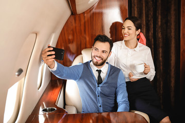 Couple taking selfie on board the modern private airplane