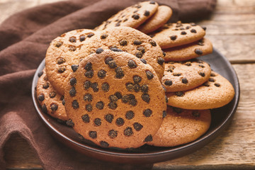 Plate with tasty cookies on wooden background