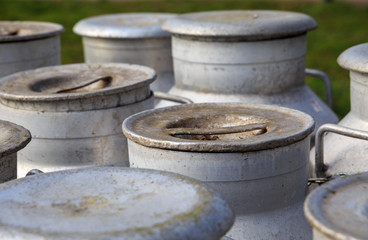 Naklejka premium Lids of traditional milk churns at an old dairy farm.