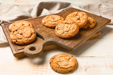 Tasty cookies with chocolate chips on wooden background