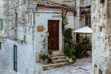 Fototapeta na wymiar facciata antica casa su strada in pietra e scale