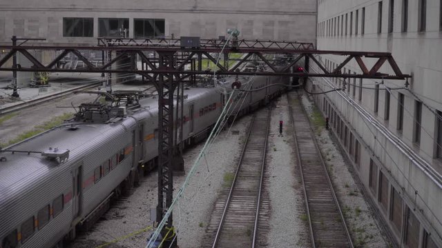 Generic railroad passenger train passing through rail yard during day time morning commute rush hour switch tracks travel to station carry people to work in urban downtown city