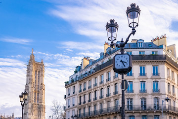 Fototapeta na wymiar Paris, the Saint-Jacques tower, with typical buildings in the center, and a clock in the street