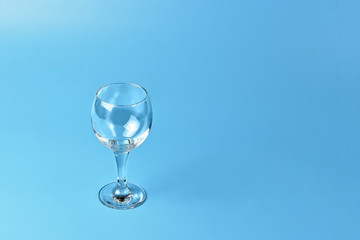 Empty wine glass on blue background