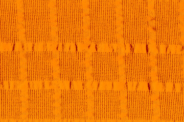 Фон желтого неровного покрытия с клетчатым рельефом.