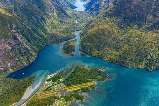New Zealand. Milford Sound (Piopiotahi) from above - the head of the fiord with wharf and Milford Sound Airport. There is Arthur River and Lake Ada in the background