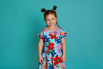 Little girl in on a blue background. Emotions of a child are anger, resentment, joy. Charming little girl smiling and showing her first lost milk tooth.