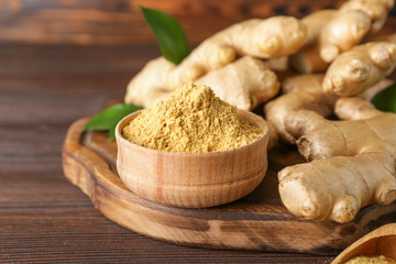Fresh and ground ginger on wooden table