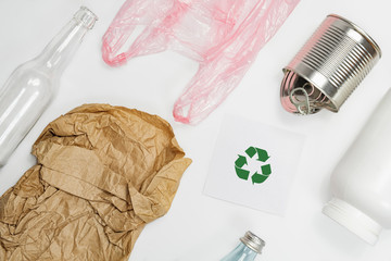 Recycling sign among different types of recyclable garbage on white background. Zero waste and...