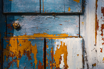 Vivid colors of layers of peeling paint on an old wooden board.