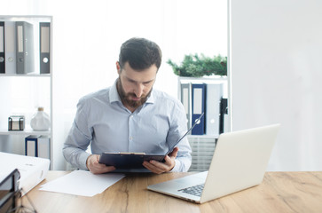 Bearded man working in the office.